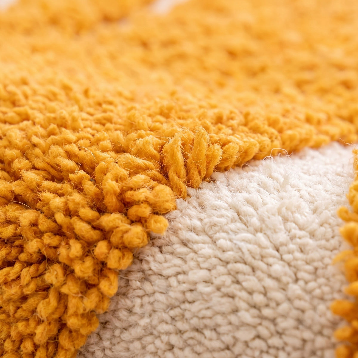 Gros plan sur un motif du tapis berbère Aridal, motifs jaune safran à poil long