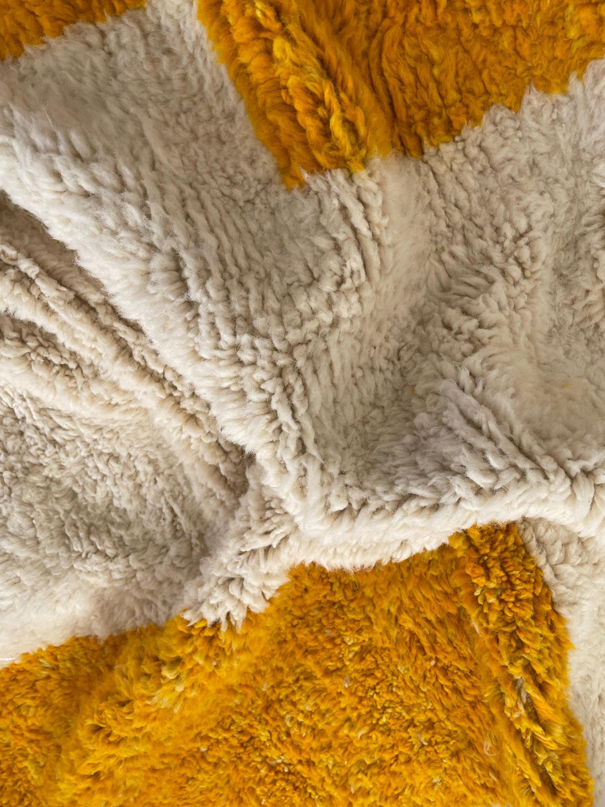 Gros plan sur la laine du tapis berbère Midelt, nœuds serrés et tracé du motif de près