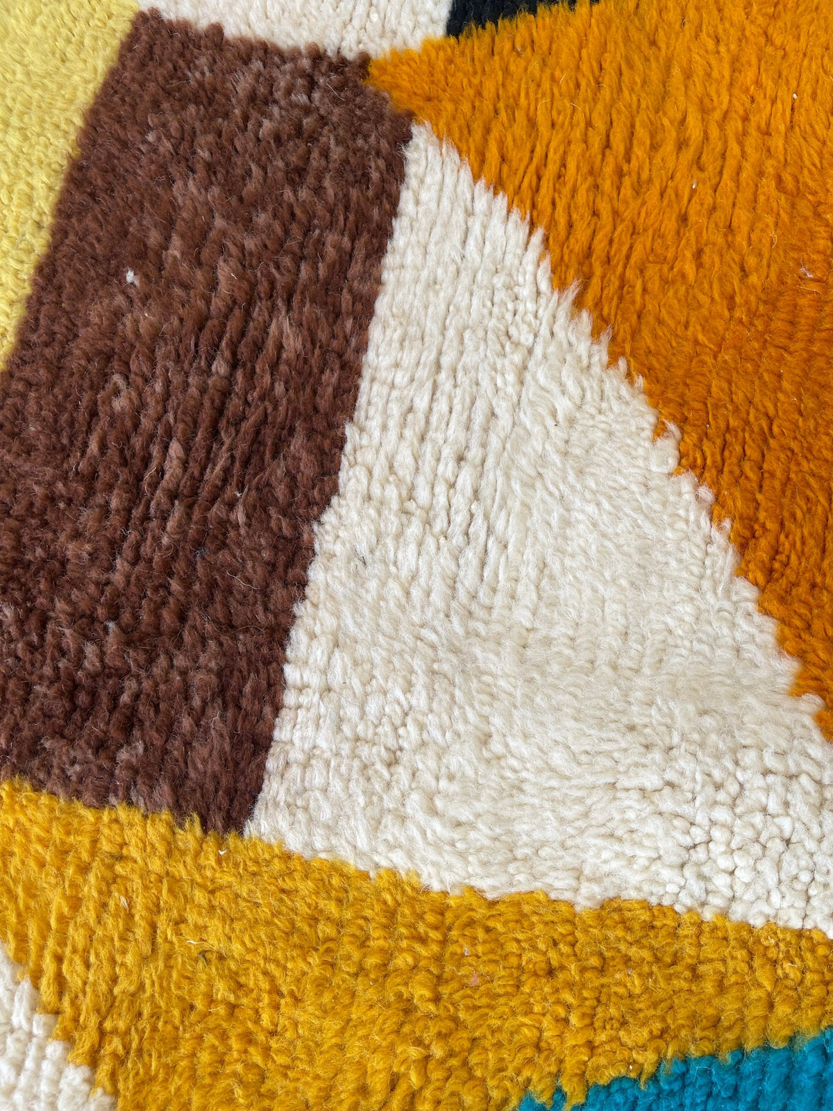 Gros plan sur la laine du tapis berbère Amloun, nœuds serrés et tracé du motif de près