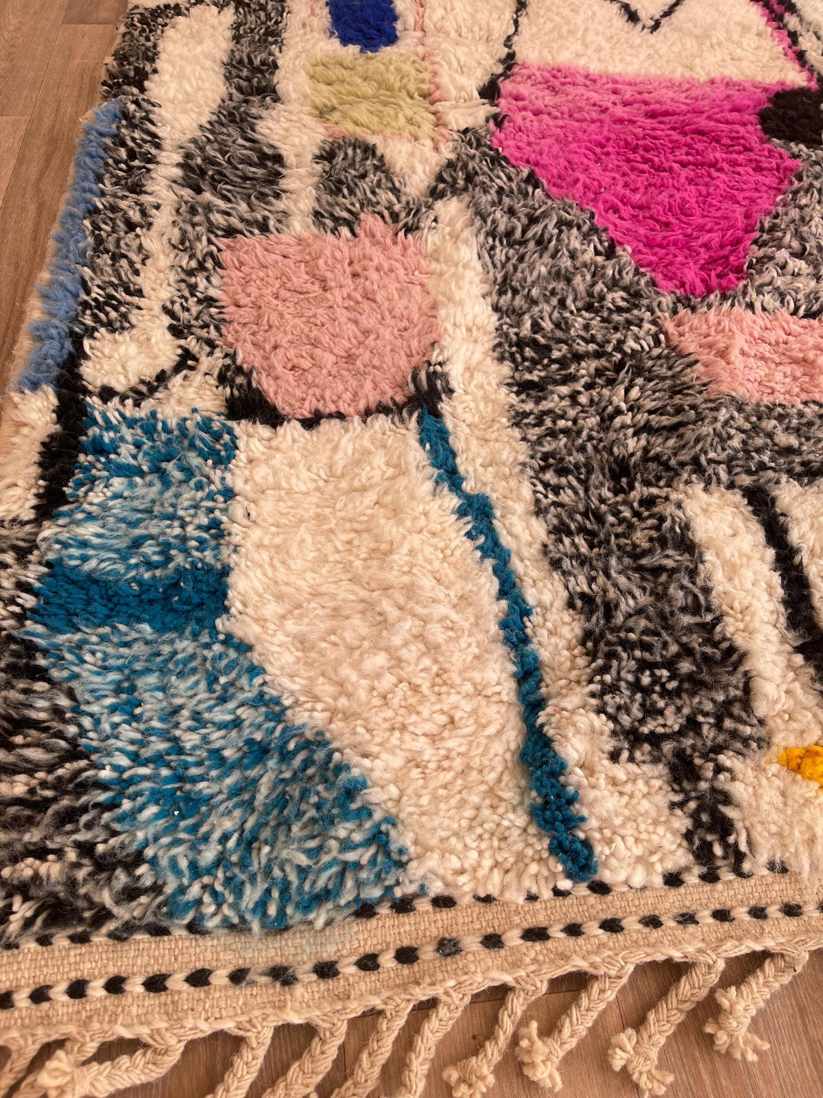 Gros plan sur les franges du tapis berbère Ijoukak, nouées à la main sur la chaîne de coton