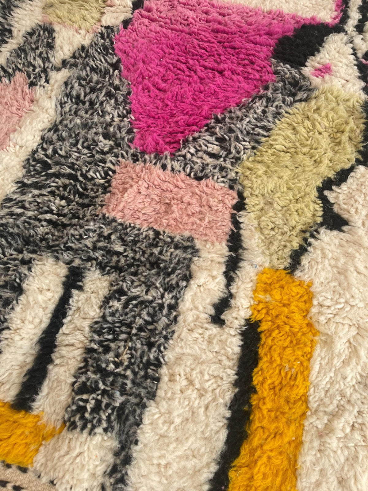 Gros plan sur la laine du tapis berbère Ijoukak, laine de mouton au poil long, multicolore