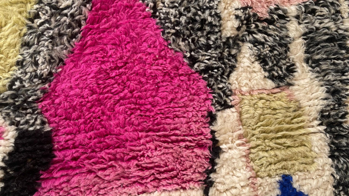 Gros plan sur la laine du tapis berbère Ijoukak, poil multicolore noué à la main