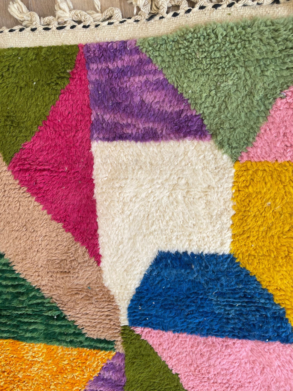 Gros plan sur la laine du tapis berbère Mezrouan, relief de la laine et du motif à la lumière