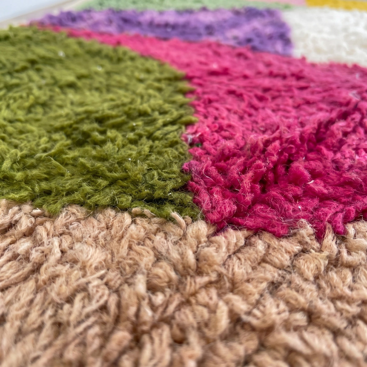 Gros plan sur un motif du tapis berbère Mezrouan, triangles colorés en éventail, en haut olive