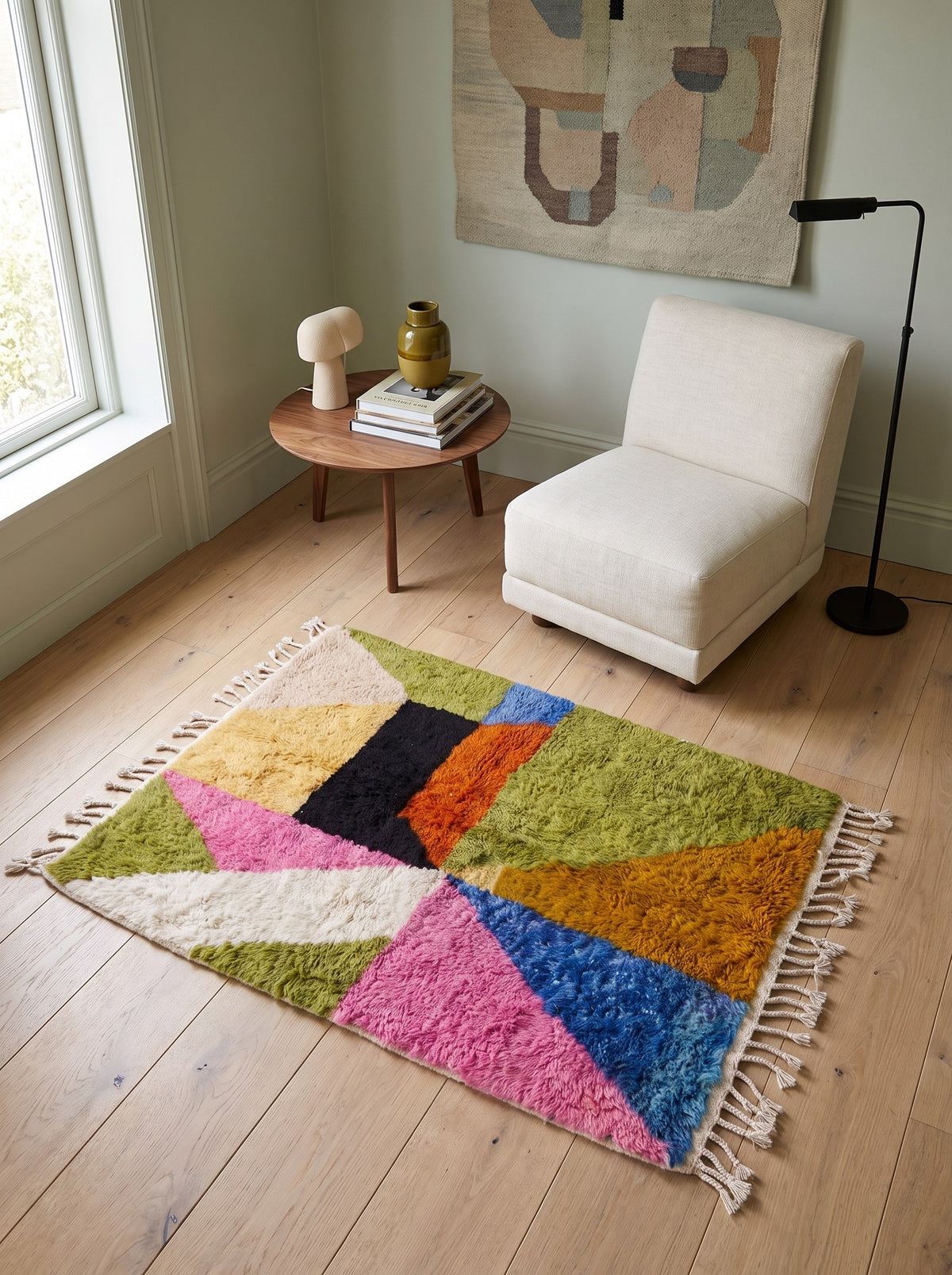 Tapis berbère graphique multicolore Tidiquin dans un coin lecture, noué main au Maroc
