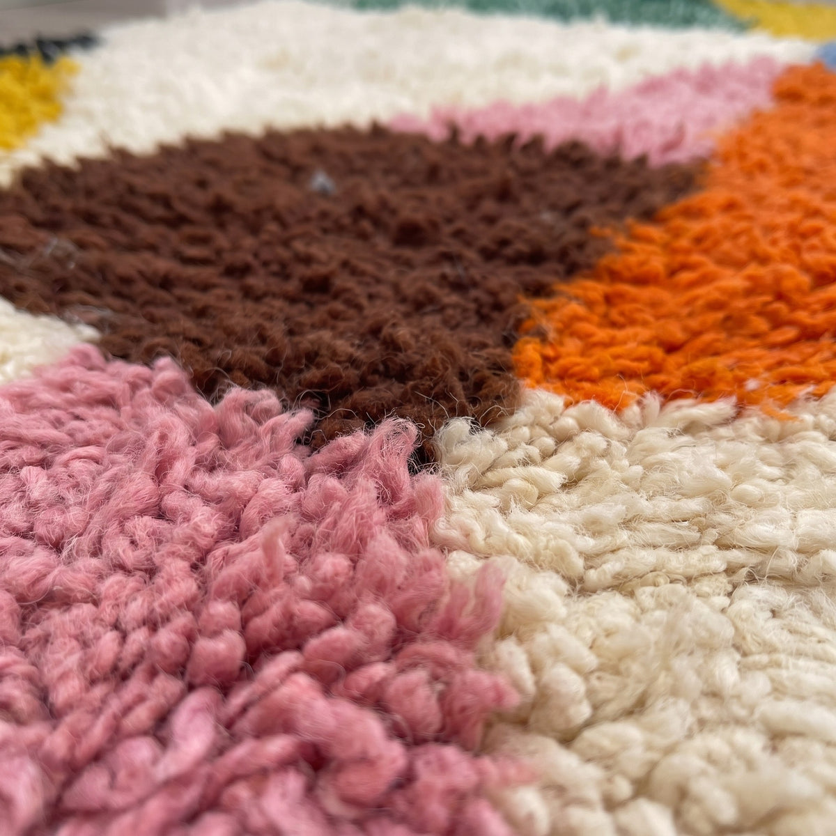 Gros plan sur un motif du tapis berbère Tiwizi, triangles rayonnants, en haut écru, triangle noir