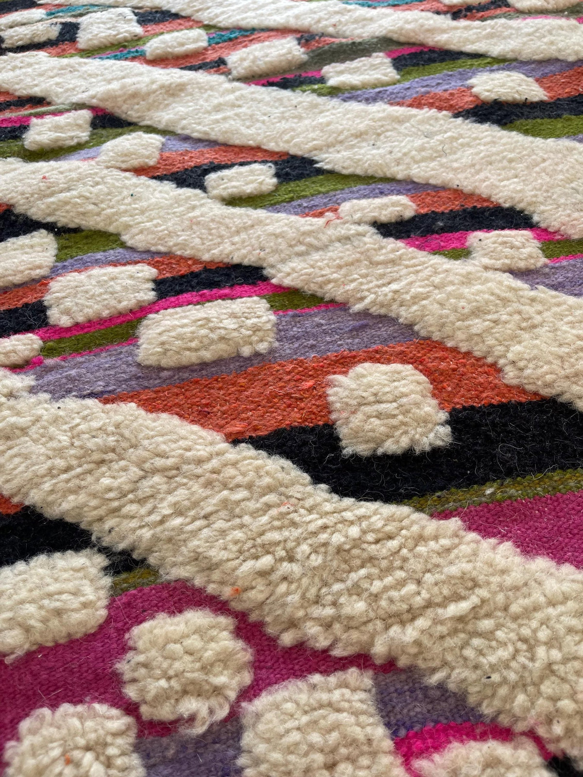 Gros plan sur la laine du tapis berbère Yebrir, poil multicolore noué à la main