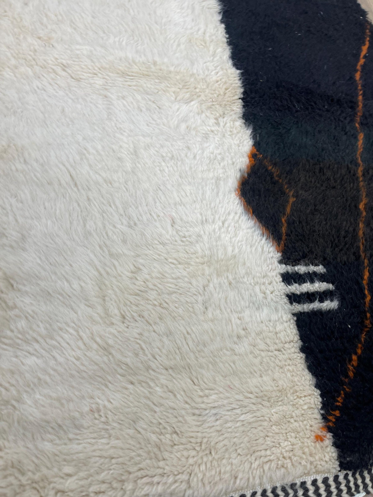 Gros plan sur la laine du tapis berbère Sabrilt, nœuds serrés et tracé du motif de près