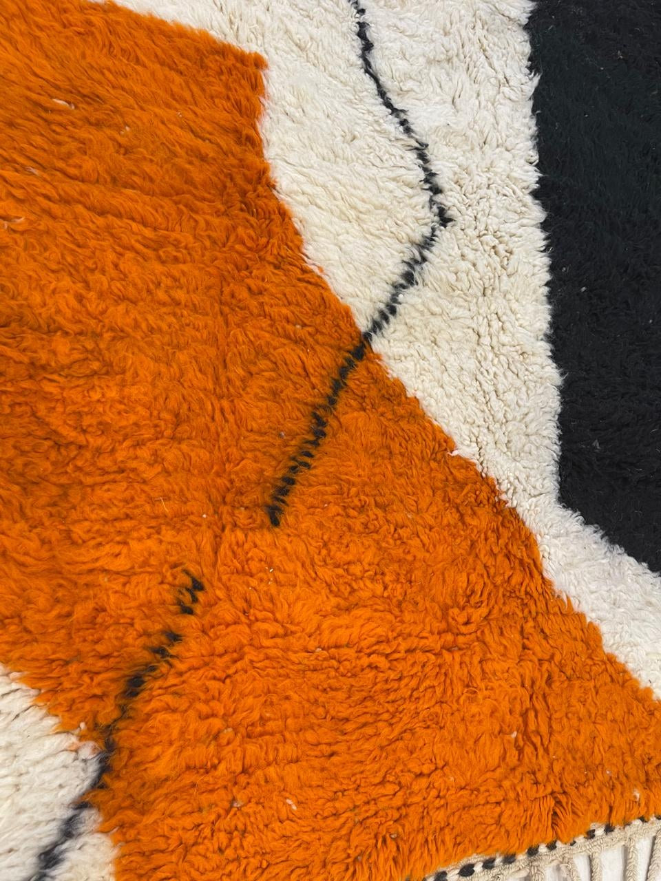 Gros plan sur la laine du tapis berbère Mouzal, nœuds serrés et tracé du motif de près