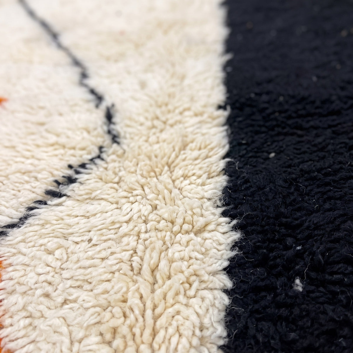 Gros plan sur un motif du tapis berbère Mouzal, grand pan noir vertical sur la moitié gauche