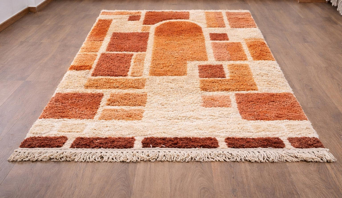 Tapis berbère graphique orange et blanc Tabburt posé au sol vu de côté, noué main au Maroc