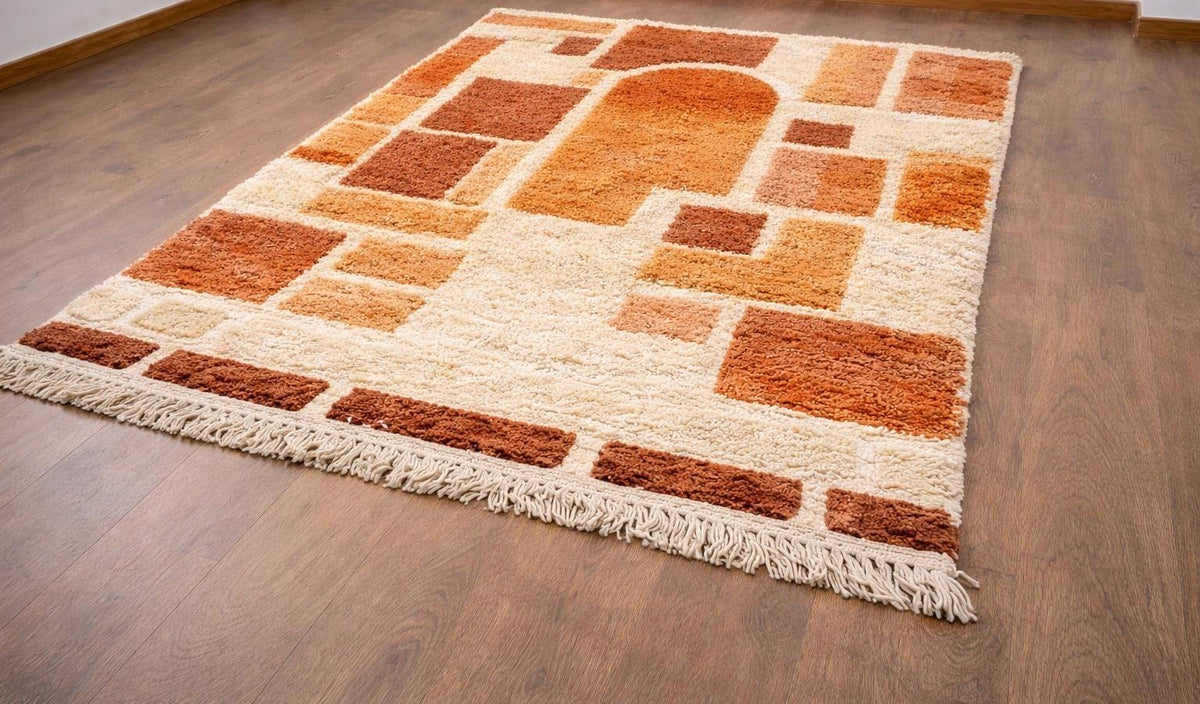 Tapis berbère graphique orange et blanc Tabburt posé au sol vu en biais, noué main au Maroc