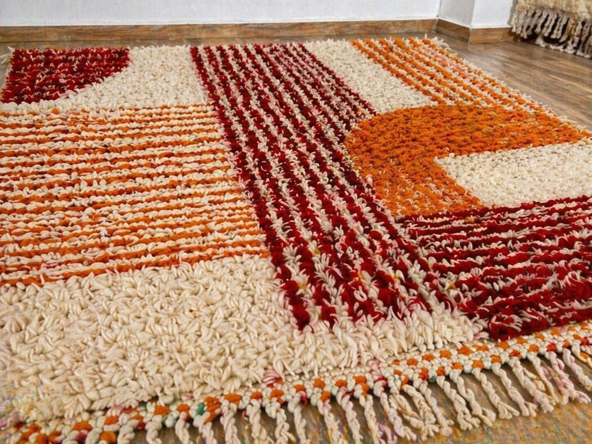 Close-up of the wool of the Tawwurt Berber rug, long-pile sheep's wool in orange and burgundy