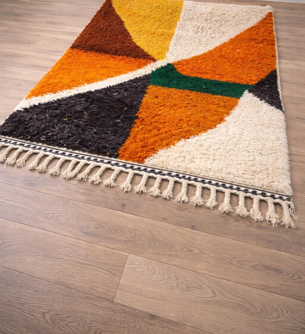 Amayas graphic Berber rug in orange and mustard, on the floor, seen from the side, hand-knotted in Morocco