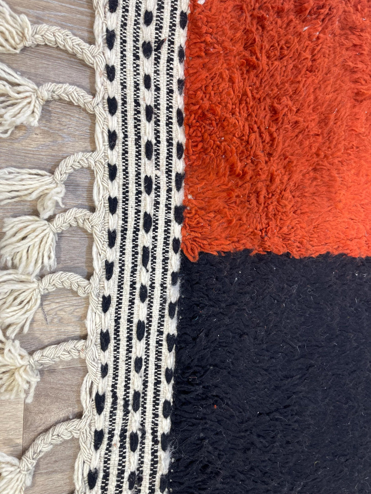 Close-up of the fringes on the Guelmim Berber rug, ecru, braided, with tassels, knotted by hand