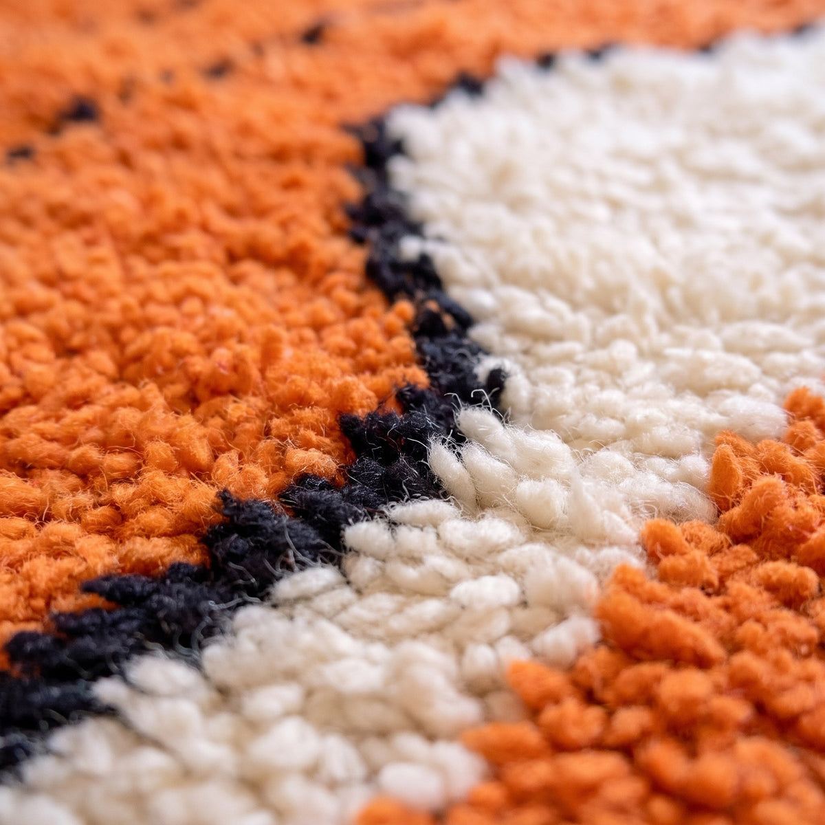 Close-up of a motif on the Sourzan Berber rug, bright orange long-pile ground