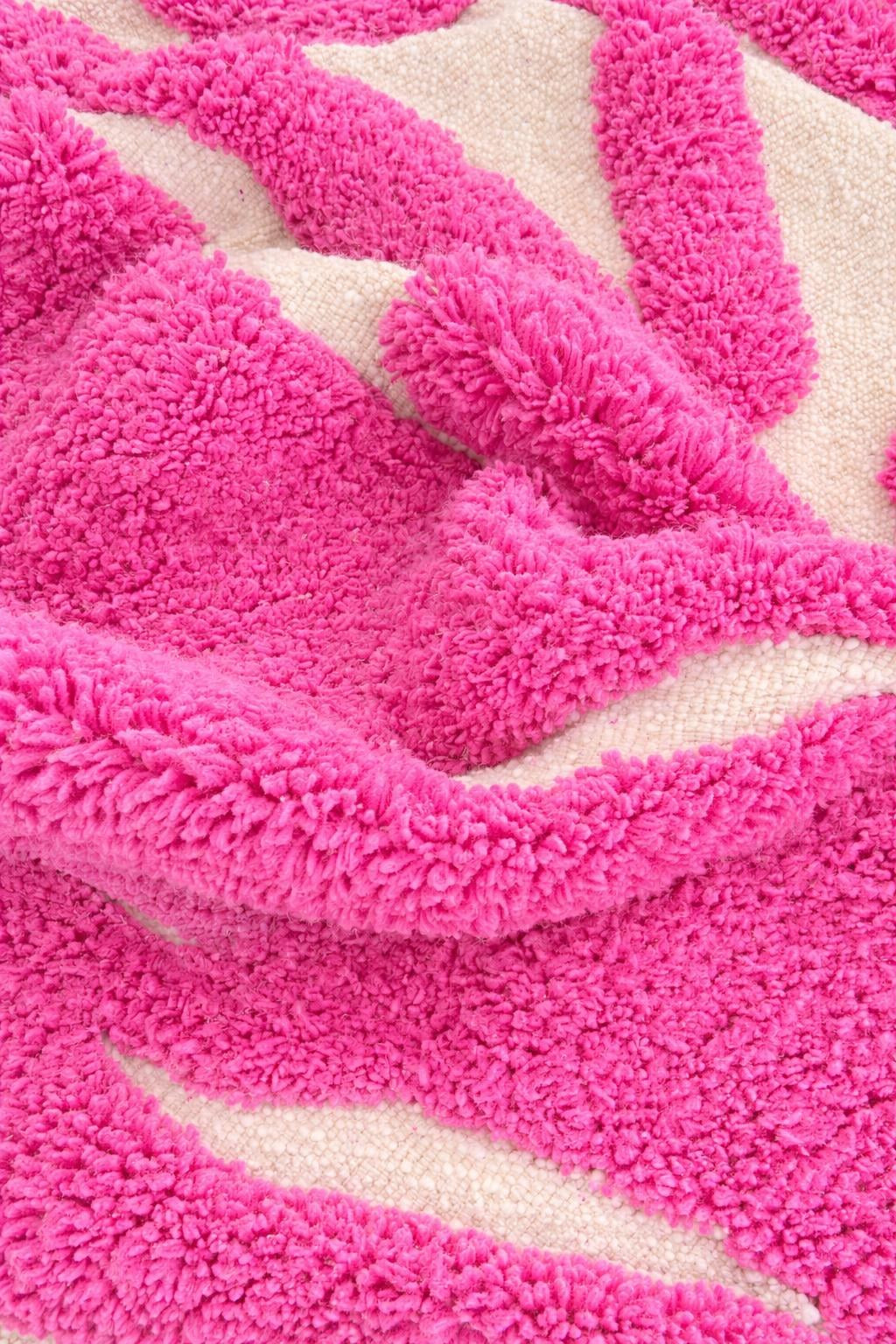 Gros plan sur la laine du tapis berbère Izmal, laine de mouton au poil moyen, rose fuchsia
