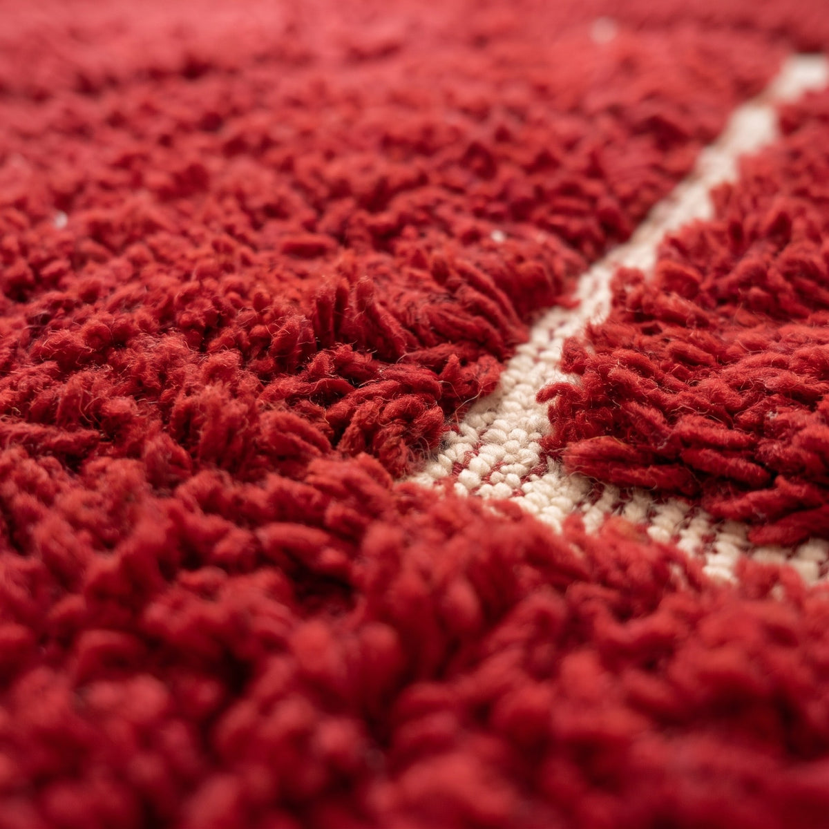 Close-up of a motif on the Telouet Berber rug, deep red long pile, fine ivory lines