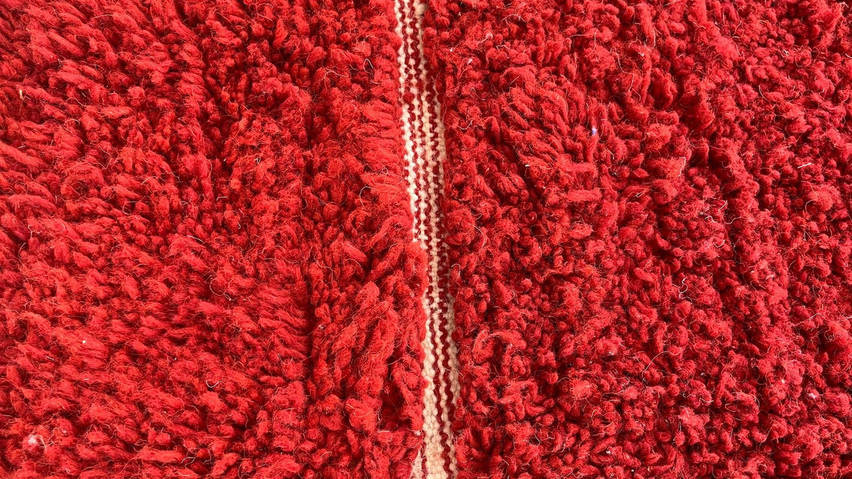 Gros plan sur la laine du tapis berbère Telouet, poil rouge noué à la main