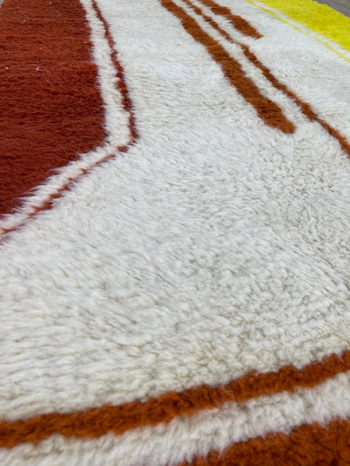 Close-up of the wool of the Haouza Berber rug, long-pile sheep's wool in rust and yellow