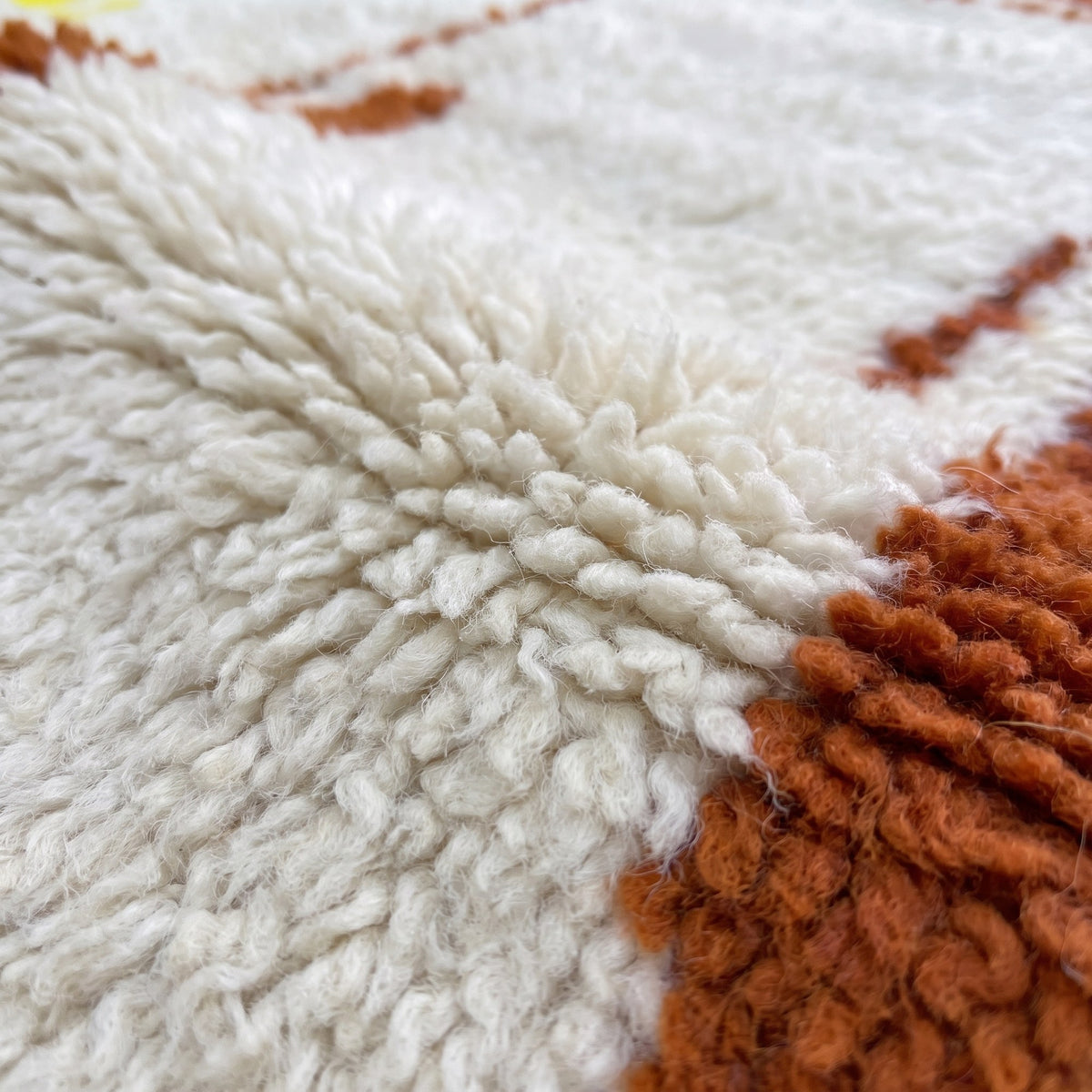 Close-up of a motif on the Haouza Berber rug, long-pile ecru field, wide burgundy band