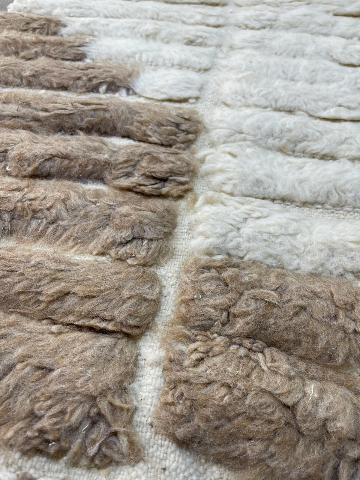 Gros plan sur la laine du tapis berbère Tarkeddit, texture de la laine naturelle et nuances du poil