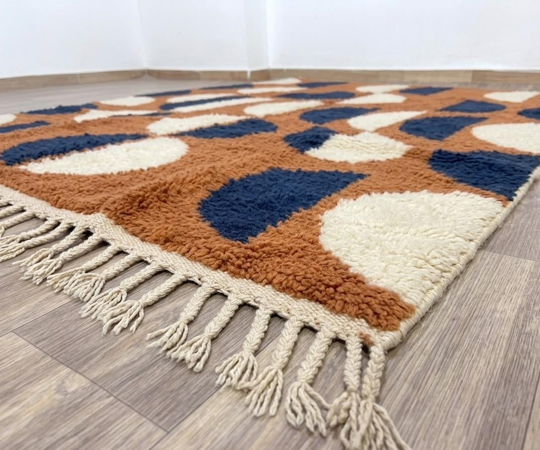 Gros plan sur le coin relevé du tapis berbère Ziri, épaisseur du poil long et dos tissé à la main
