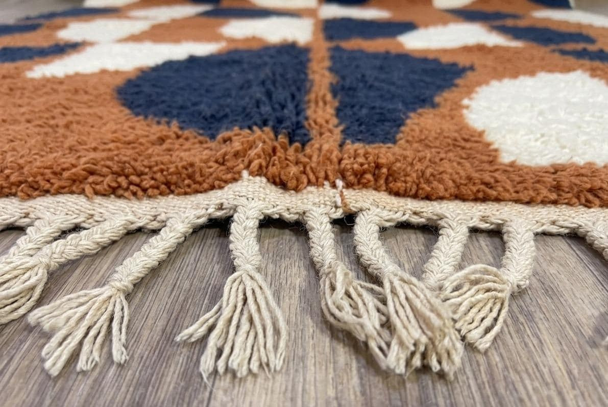 Gros plan sur les franges du tapis berbère Ziri, écrues nouées en bas, nouées à la main