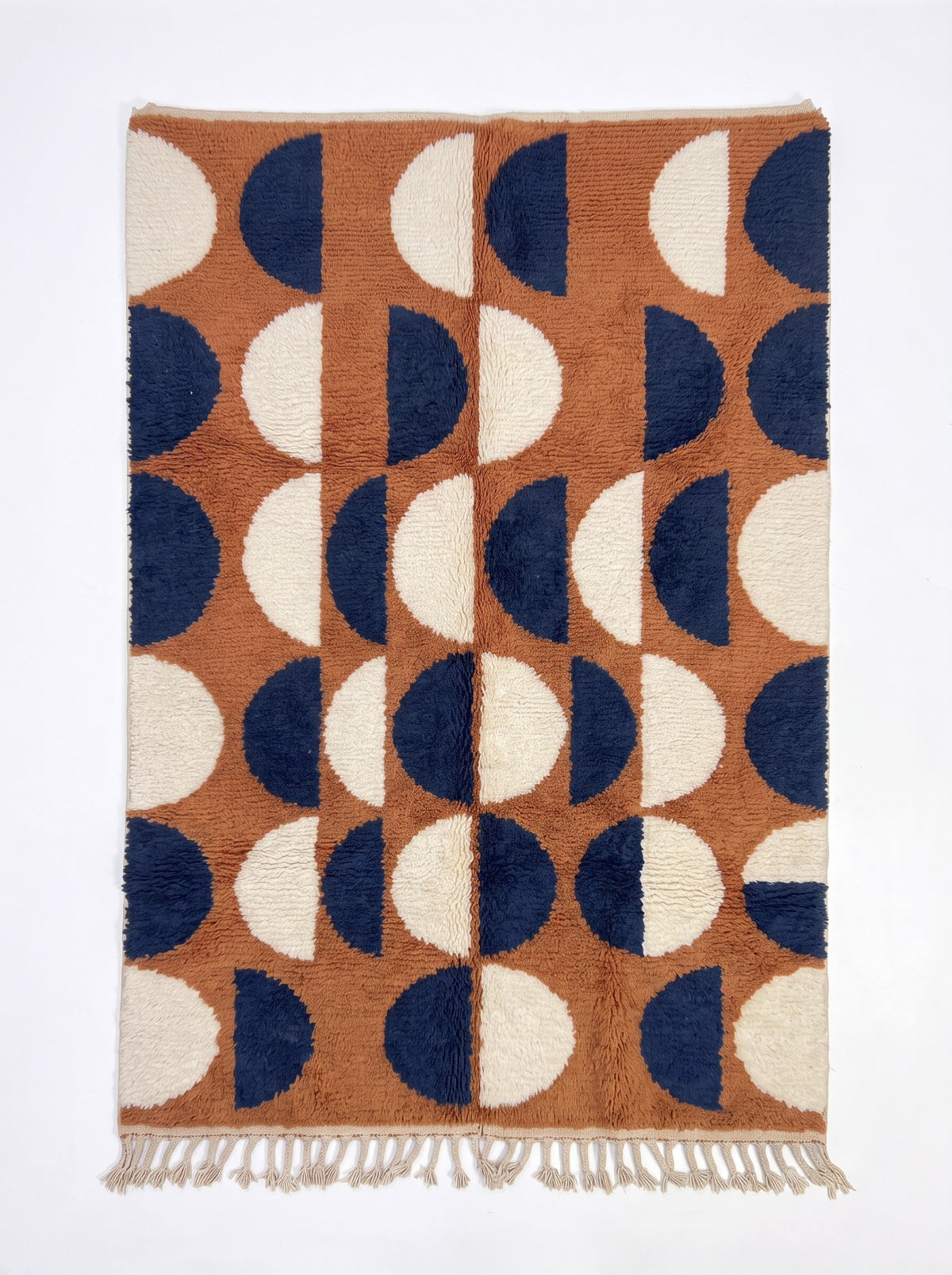 Tapis berbère graphique terracotta et bleu nuit Ziri vu à plat, fond cognac, six rangées de demi-disques bleu marine et écrus