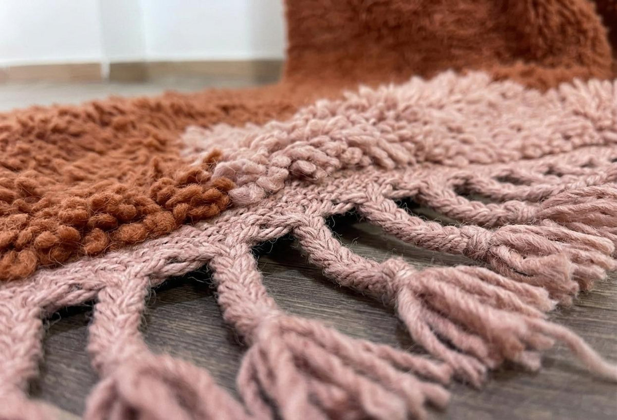 Close-up of the fringes on the Tarmizt Berber rug, powder pink, at the bottom only, knotted by hand