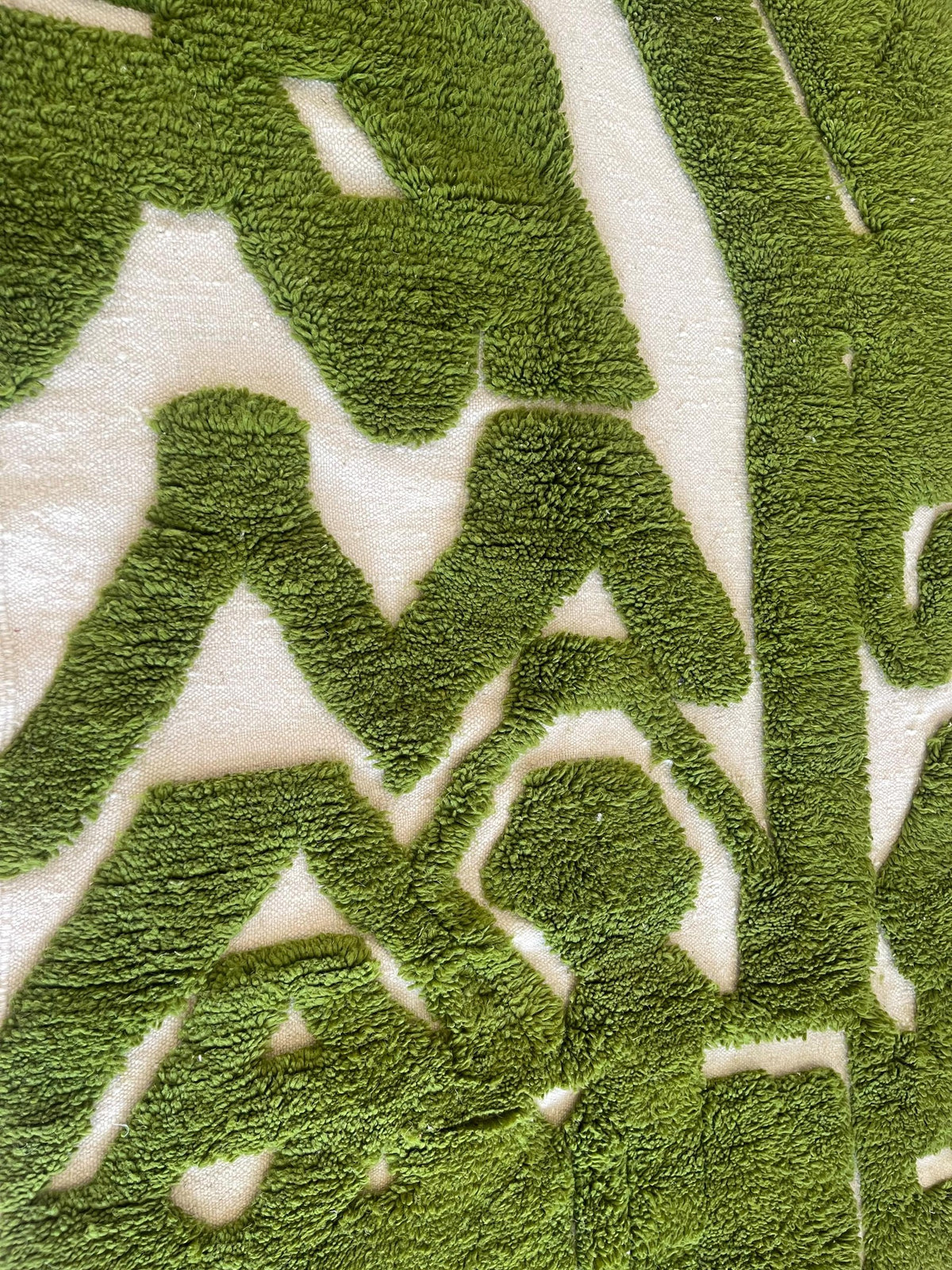 Gros plan sur la laine du tapis berbère Maamora, nœuds serrés et tracé du motif de près