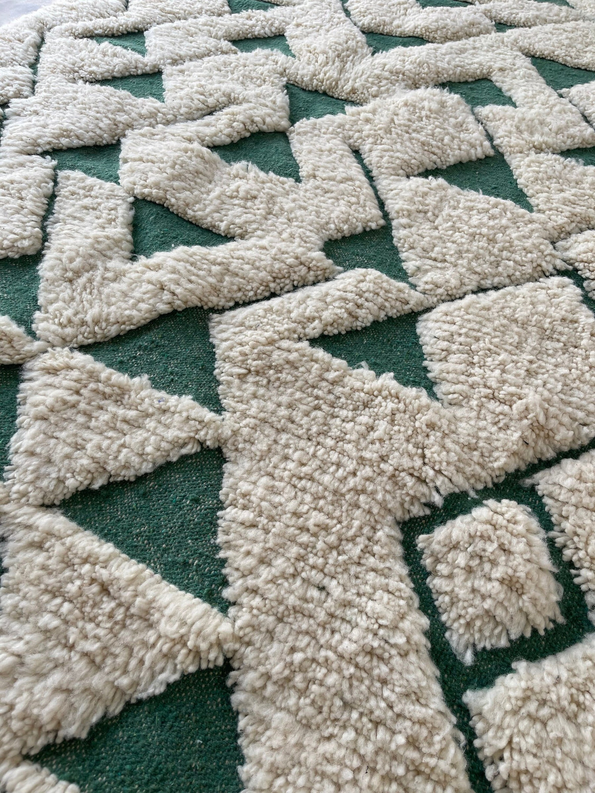 Gros plan sur la laine du tapis berbère Sezlan, nœuds serrés et tracé du motif de près