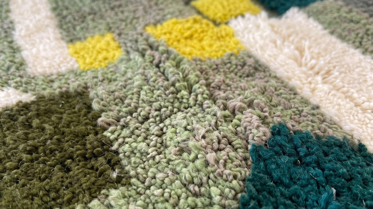 Gros plan sur la laine du tapis berbère Taliouine, poil vert et jaune noué à la main