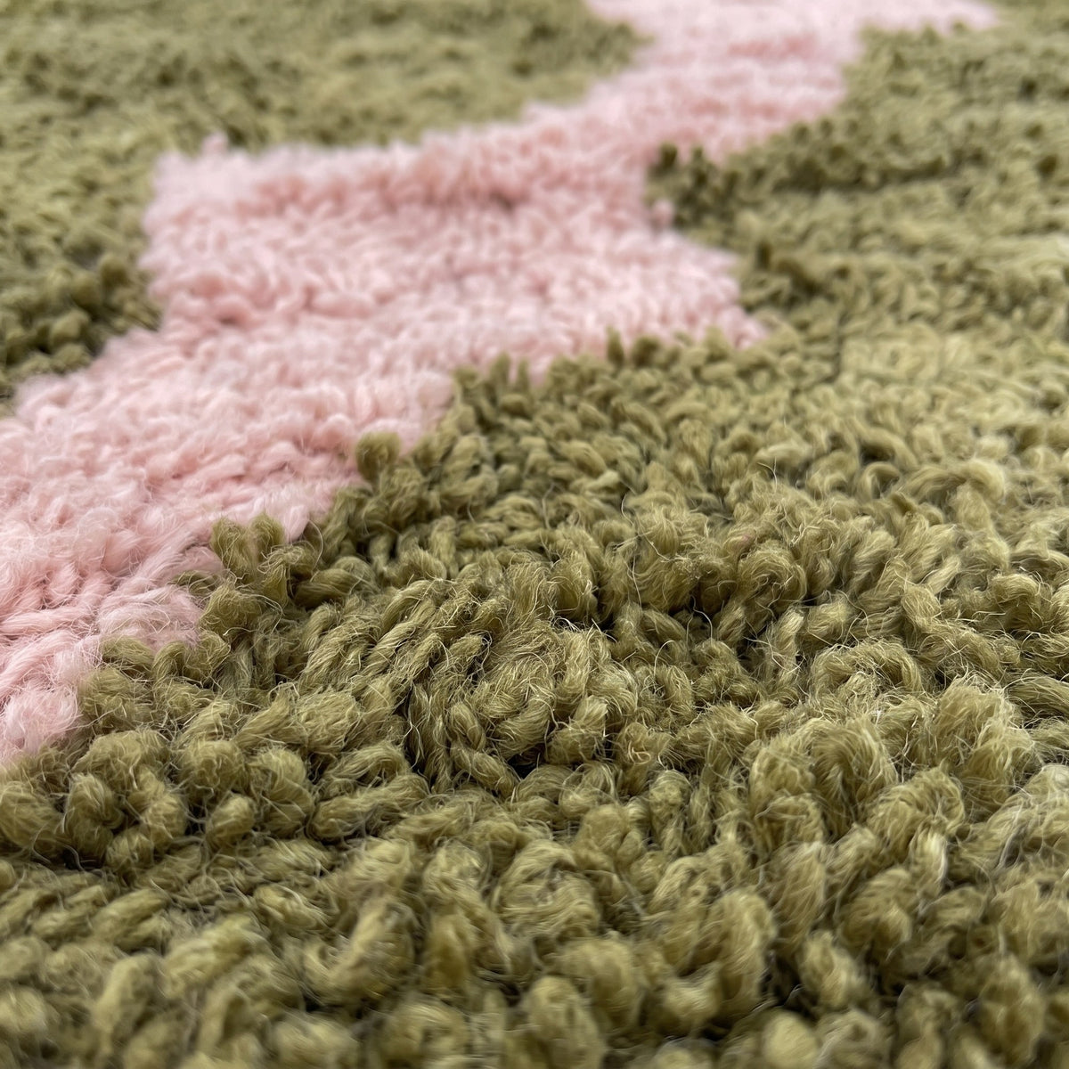 Gros plan sur un motif du tapis berbère Nekor, fond vert olive à poil long