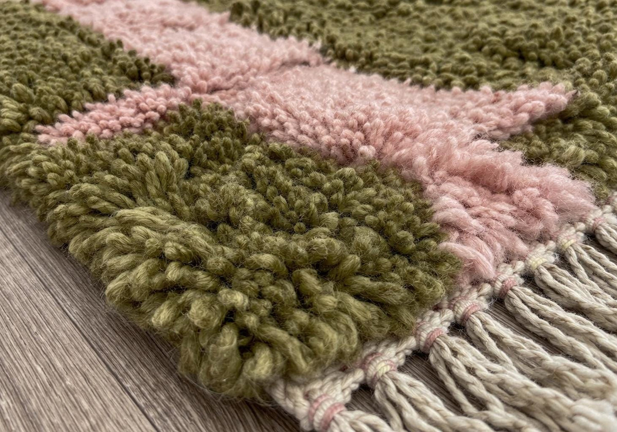 Gros plan sur la laine du tapis berbère Nekor, poil vert olive et rose
