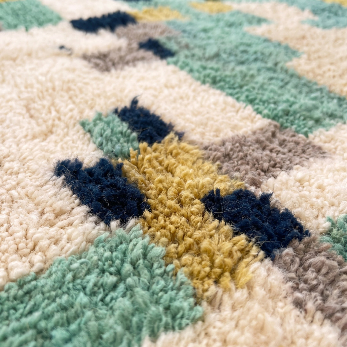Gros plan sur un motif du tapis berbère Issafen, moitié haute vert olive avec bandes vert