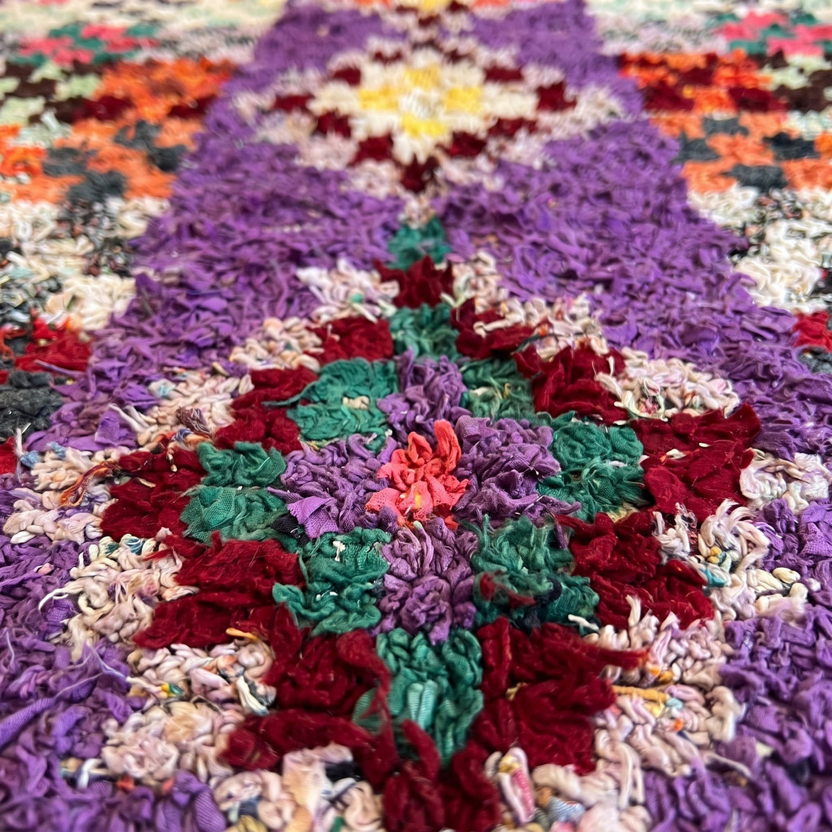 Gros plan sur un motif du tapis berbère Agim, bande centrale violette portant six losanges