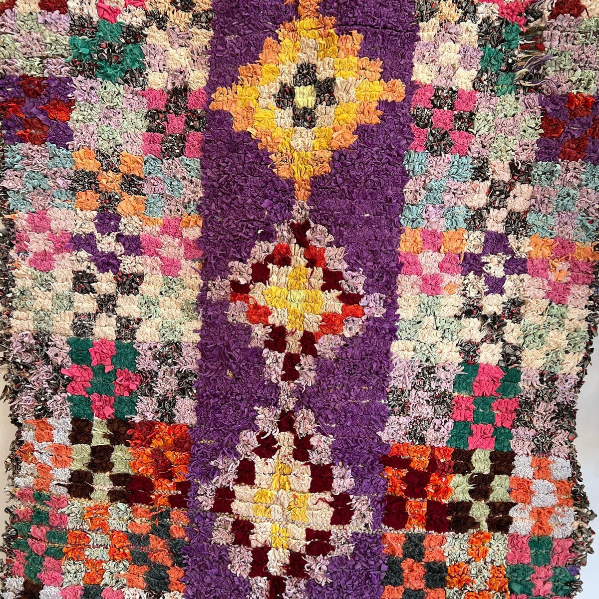 Gros plan sur la laine du tapis berbère Agim, poil violet multicolore noué à la main