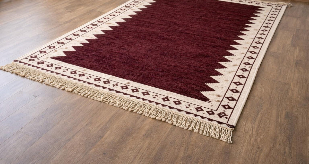 Tapis berbère kilim bordeaux et blanc Tasgalt posé au sol vu de côté, noué main au Maroc