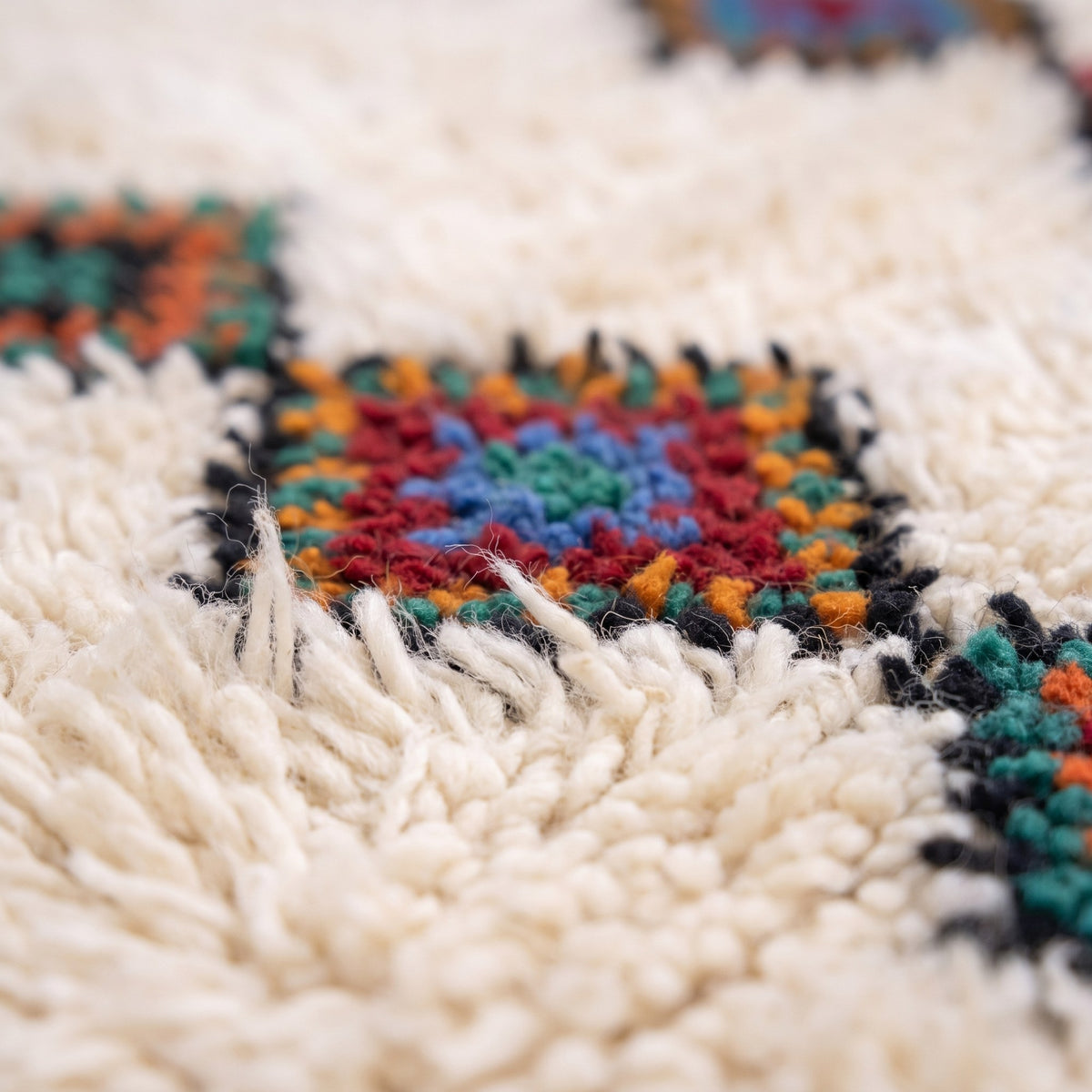 Gros plan sur un motif du tapis berbère Ifilan, fond ivoire, trois colonnes verticales parallèles