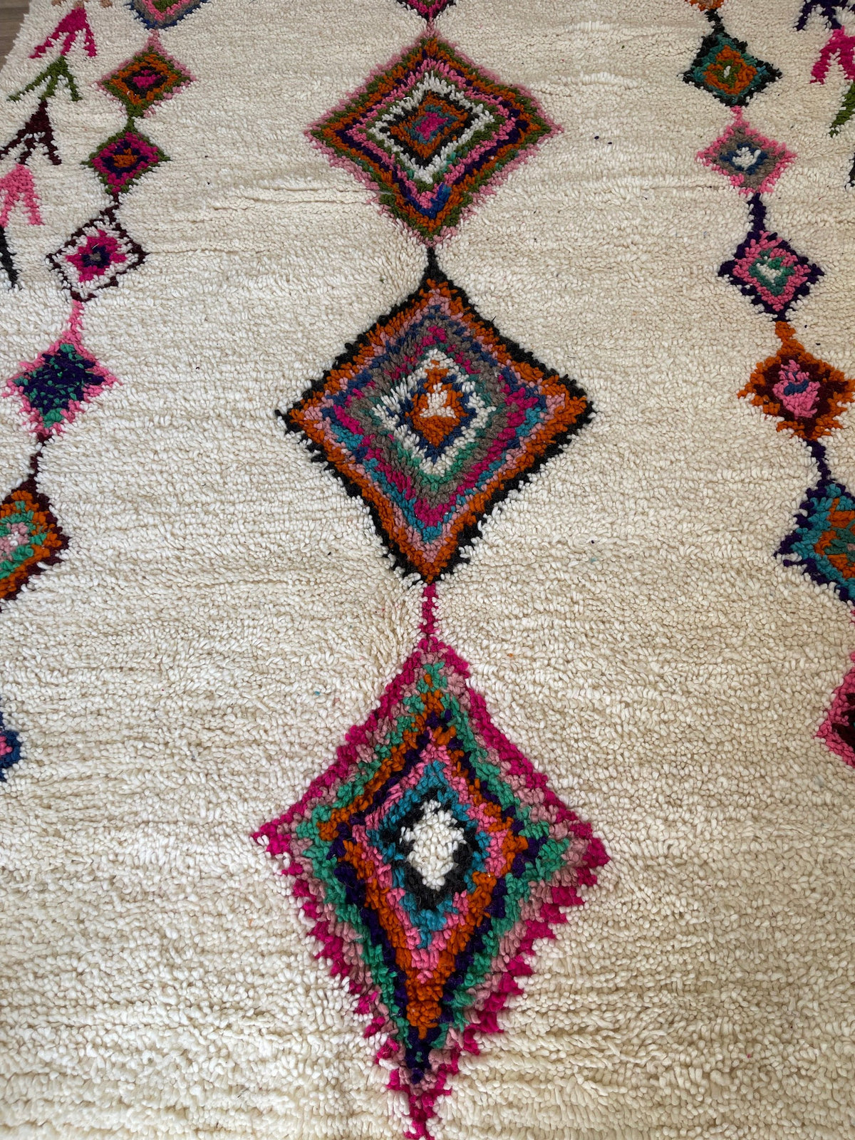 Gros plan sur la laine du tapis berbère Kessila, nœuds serrés et tracé du motif de près