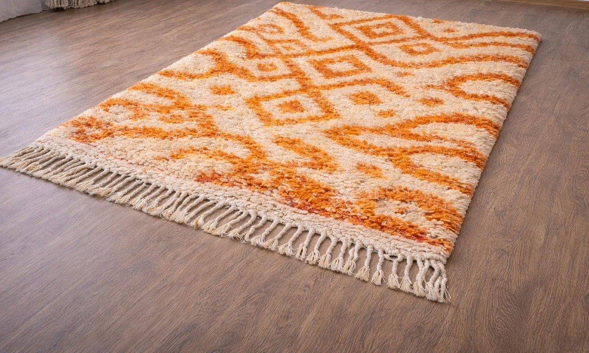 Remlia Berber rug, Azilal style, in white and orange, on the floor, seen from the side at an angle, hand-knotted in Morocco