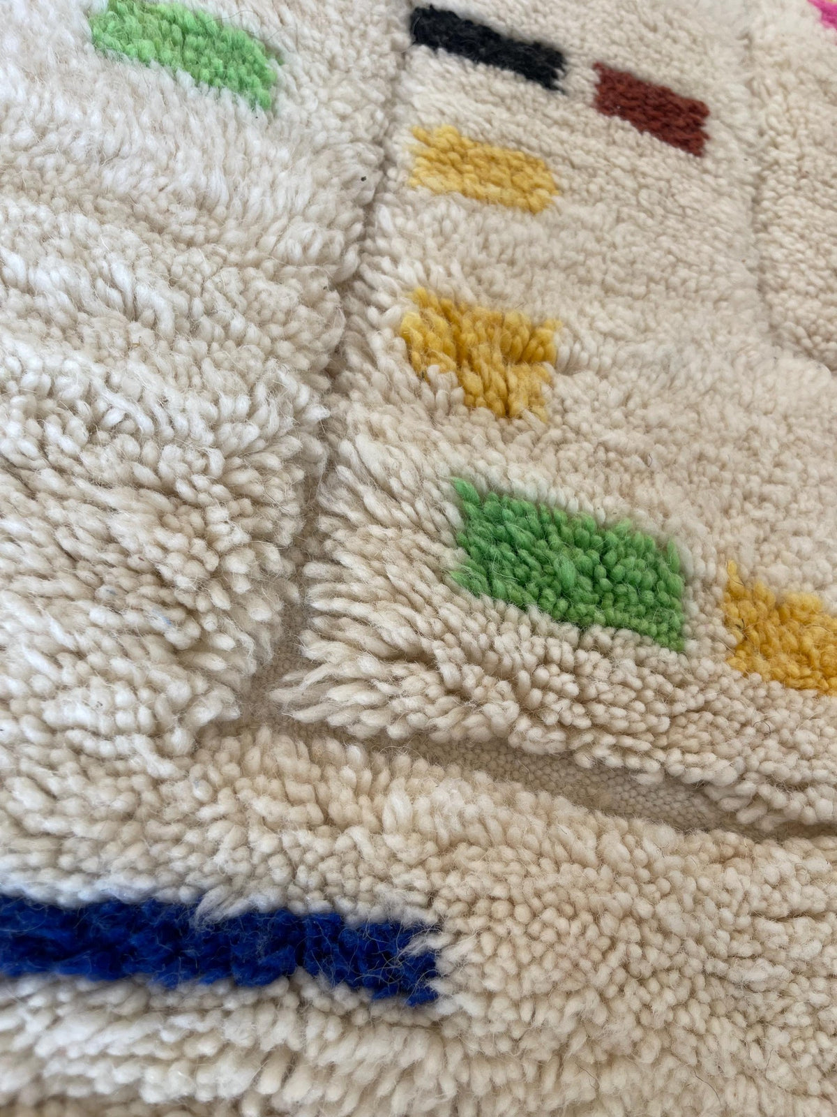 Gros plan sur la laine du tapis berbère Kermila, nœuds serrés et tracé du motif de près