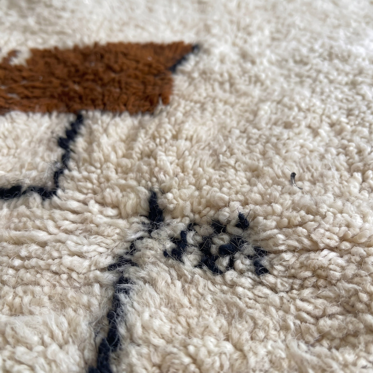 Gros plan sur un motif du tapis berbère Steha, champ écru, en haut à gauche