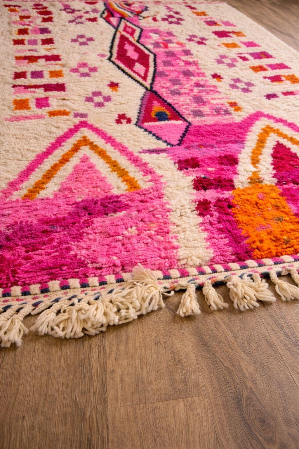 Gros plan sur la laine du tapis berbère Tirzana, poil blanc et rose noué à la main