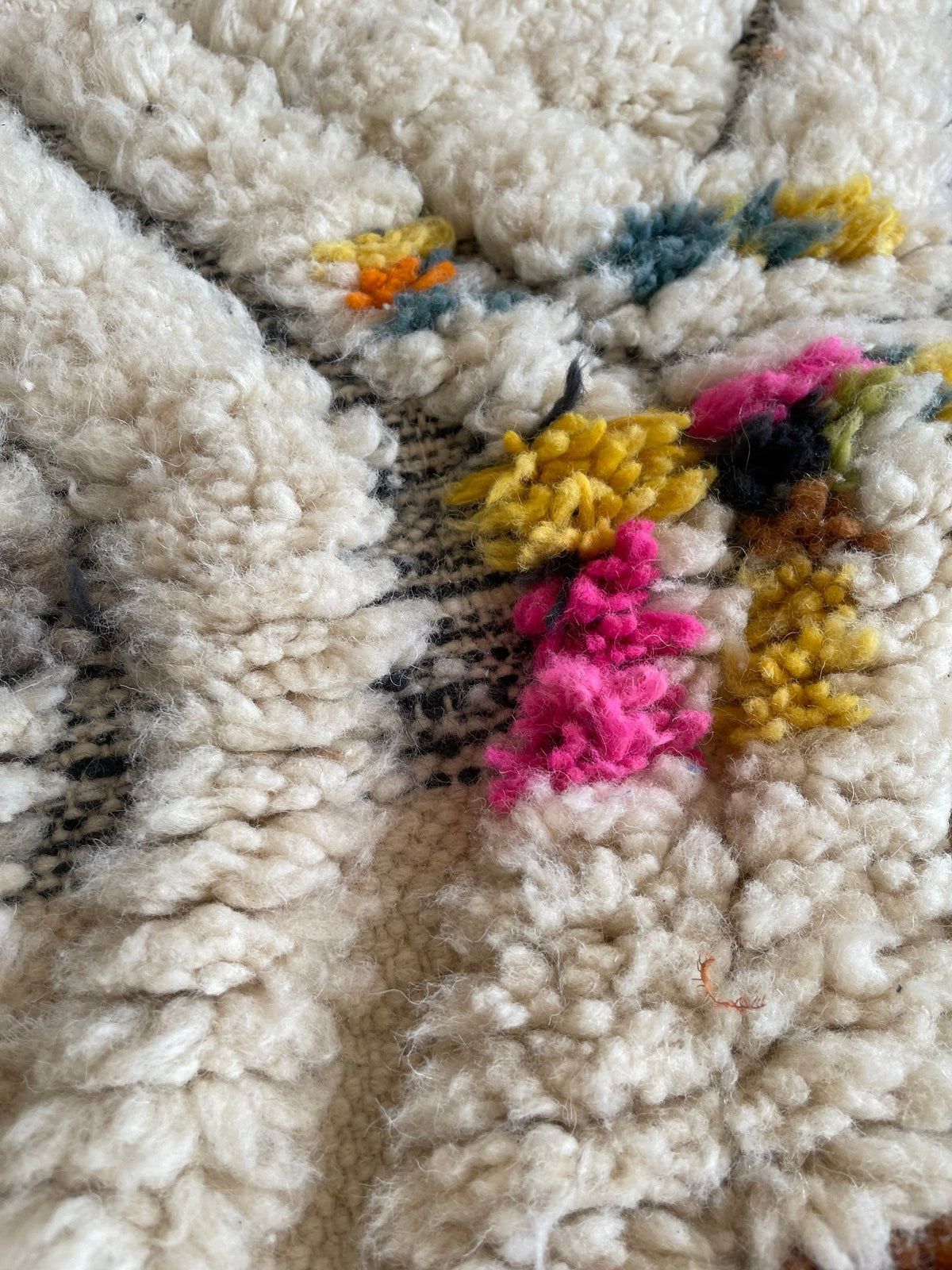 Gros plan sur la laine du tapis berbère Asni, texture de la laine naturelle et nuances du poil