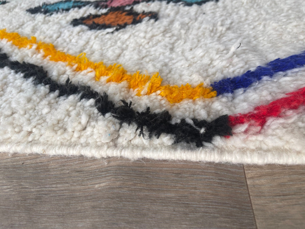 Gros plan sur la laine du tapis berbère Tafirwa, laine de mouton au poil long, blanc multicolore