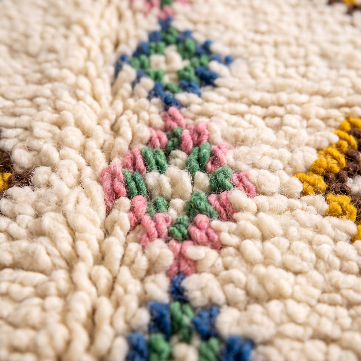 Gros plan sur un motif du tapis berbère Tafirwa, fond ivoire, deux X en haut