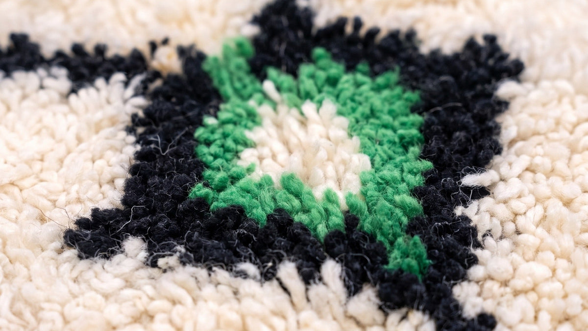 Gros plan sur la laine du tapis berbère Tifinagh, poil blanc multicolore noué à la main