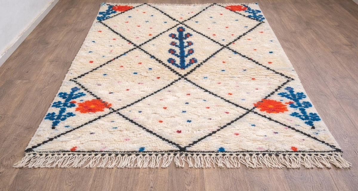 Tapis berbère style Azilal blanc, noir et bleu Timichi posé au sol vu de côté, noué main au Maroc
